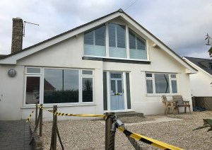 Front view of white rendered Southbourne Coast property with glazed upper level.