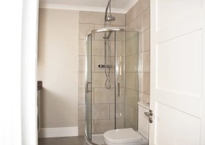 Modern tiled shower in newly renovated bathroom as part of Southampton home extension.