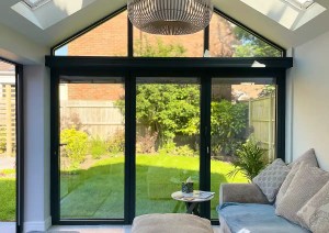 Interior of glazed sunroom extension with aluminium frames and garden views in Romsey.