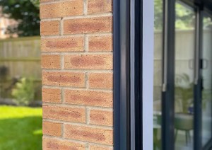 Close-up brickwork and aluminium framed door detail in Romsey sunroom extension.