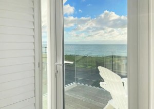 Sea view through glazed balcony doors at the Southbourne Coast home.