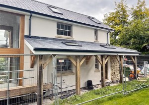 Exterior of The Cottage combining white render and flint detailing.
