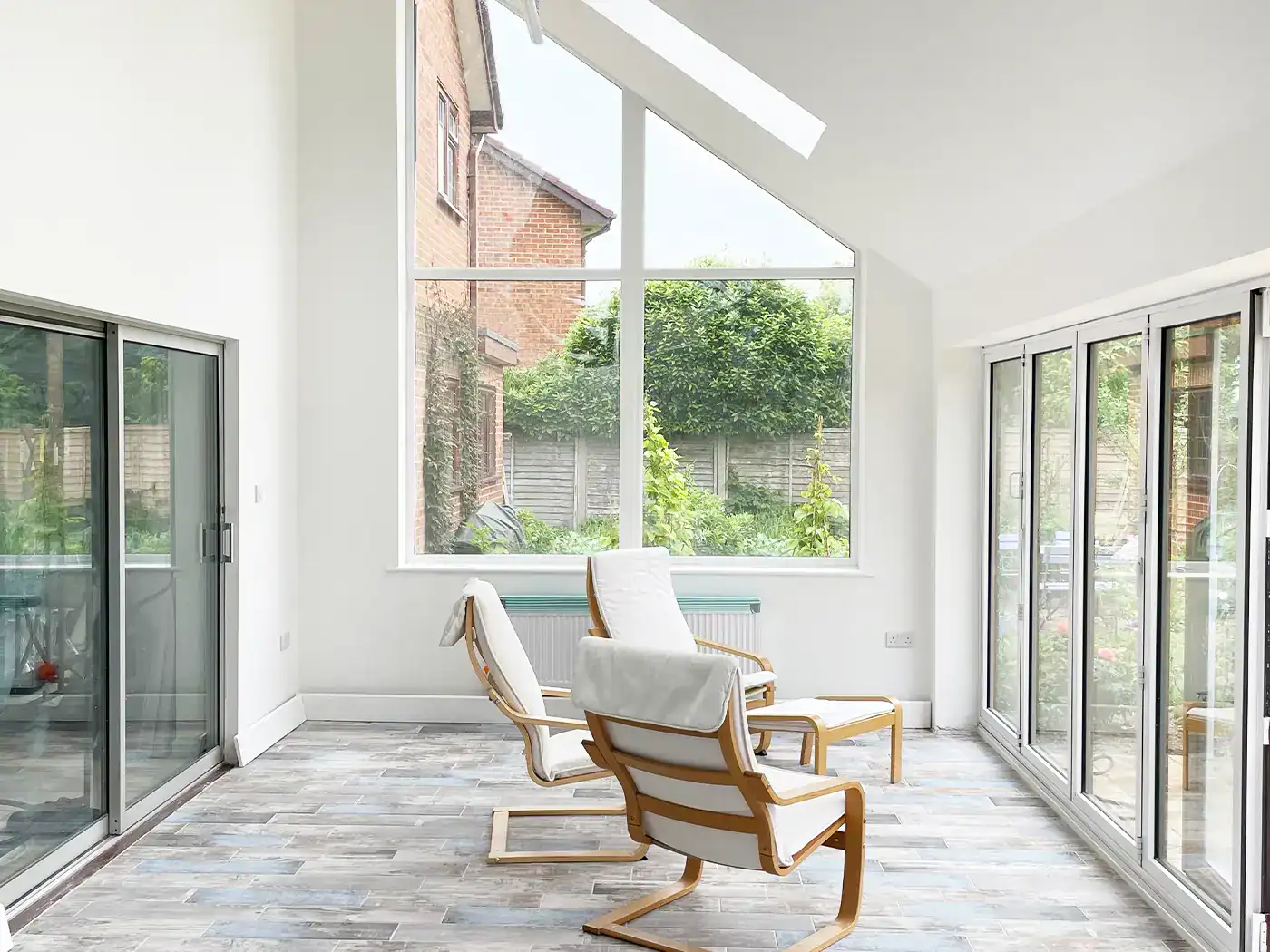 Glazed gallery-style interior space with folding doors opening onto the garden in Poole extension.