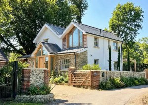View of The Cottage new build home featuring flint walls and pitched roof.