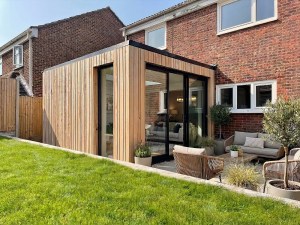 Modern single-storey timber clad home extension at Elmdale Close, Southampton with large sliding glass doors.